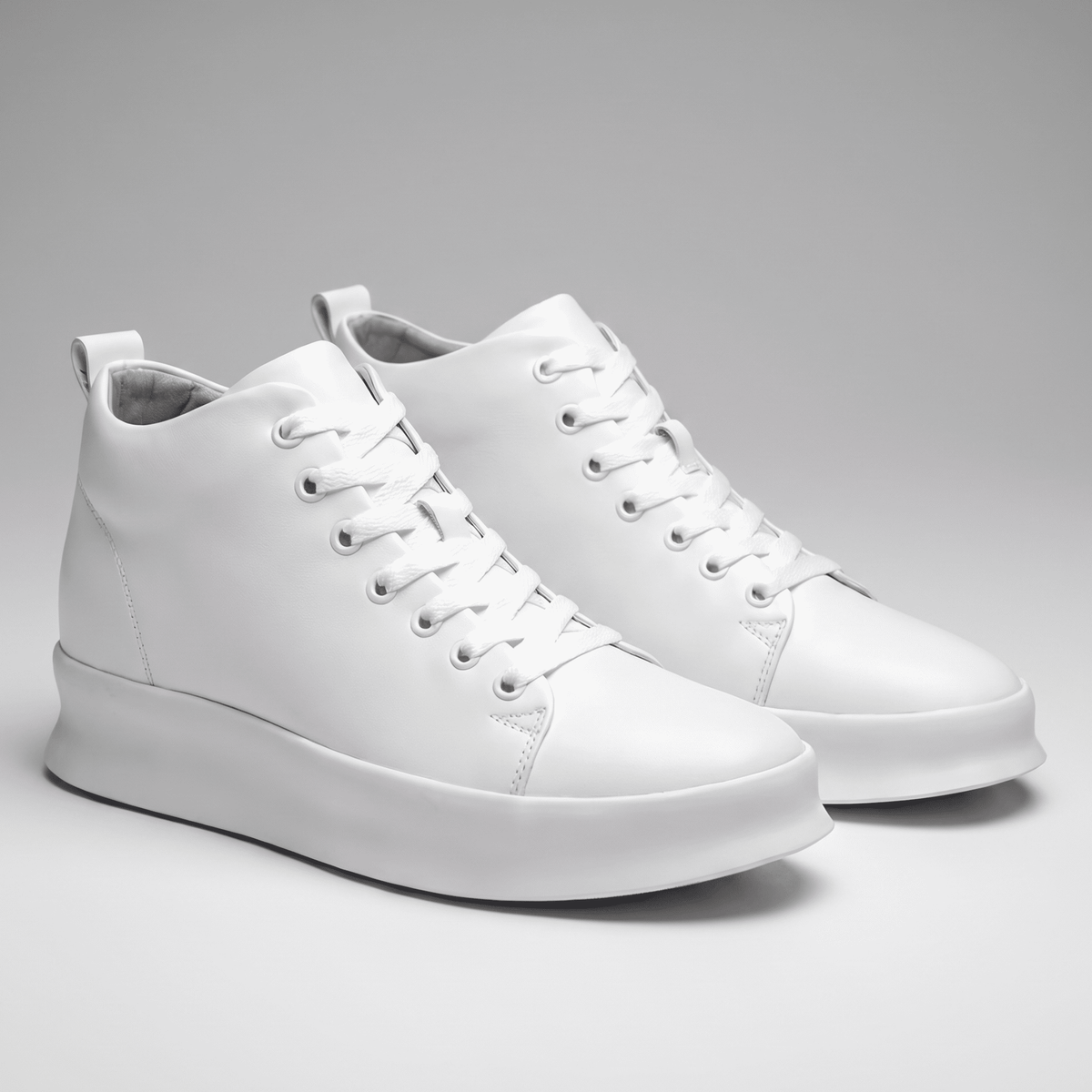 Pair of white FORCIANO ACHILLES Height Boosting Sneakers displayed from a front three-quarter angle.