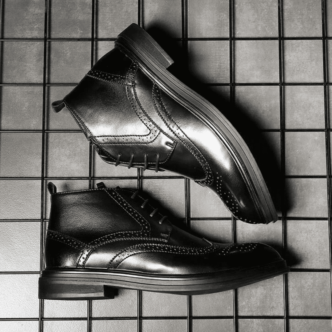 FORCIANO ALTIER black leather elevator boots shown from opposing side angles on a grid background, highlighting the ankle profile and decorative perforations.
