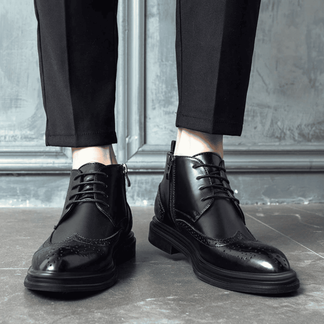 FORCIANO ALTIER black leather elevator boots worn with black trousers in a front lifestyle view, showing lace-up fronts and brogue toe detailing.