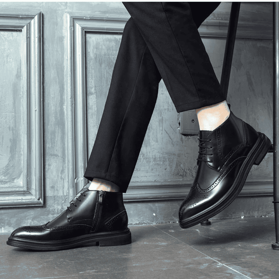 FORCIANO ALTIER black leather elevator boots shown worn in a seated lifestyle pose, displaying side and front angles with brogue accents.