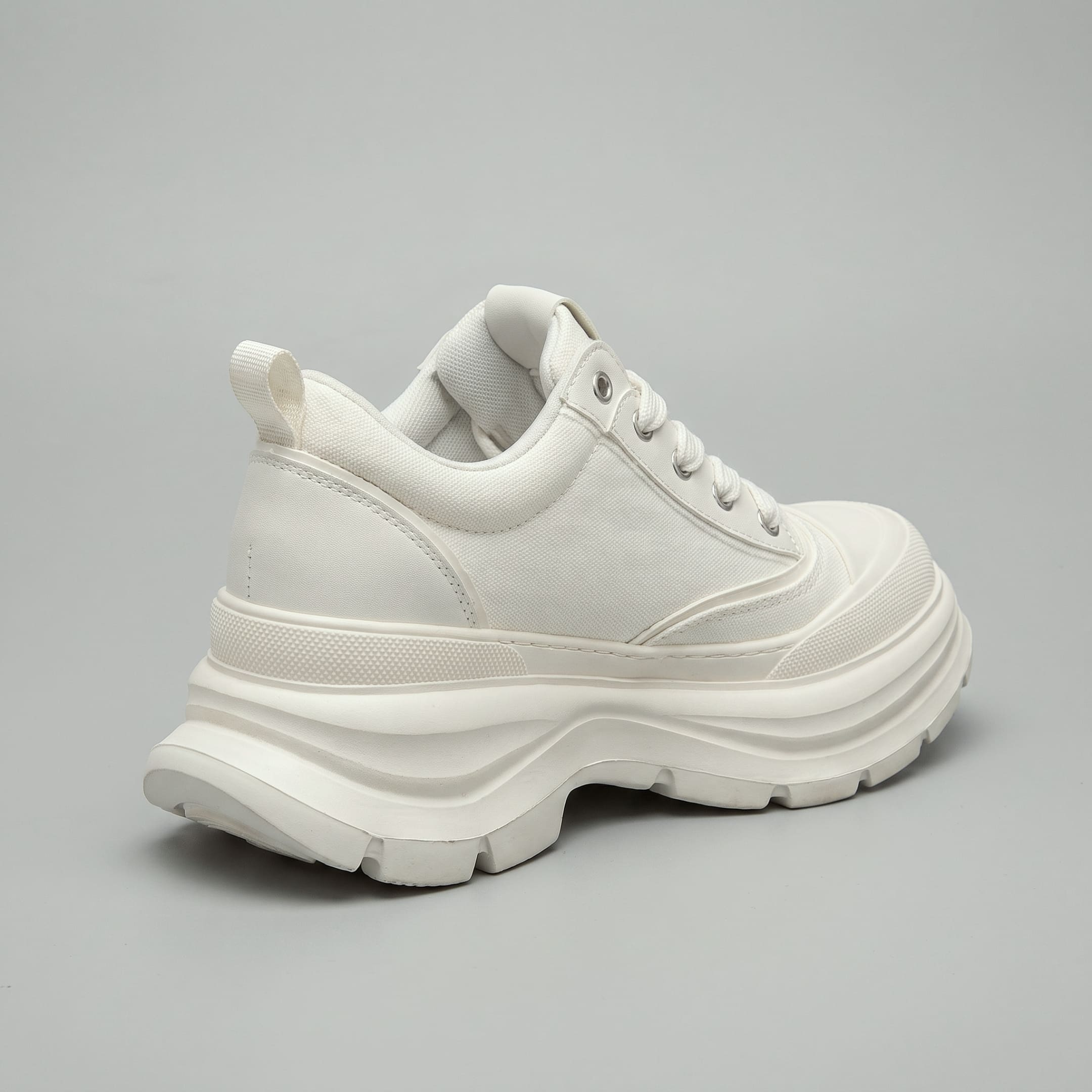FORCIANO ATLAS Beige White elevator sneaker shown from a rear three-quarter angle with its canvas and leather upper and sculpted sole visible.