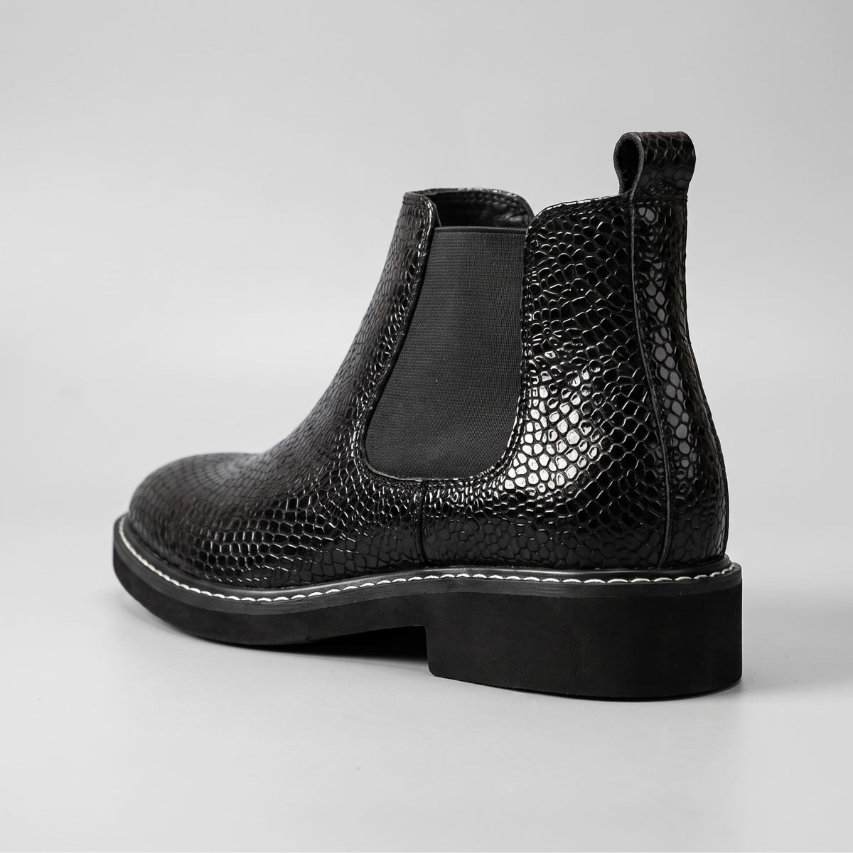 FORCIANO BRIXTON black women's elevator boot in rear three-quarter view, highlighting the textured premium leather upper, pull tab and elastic side panel.