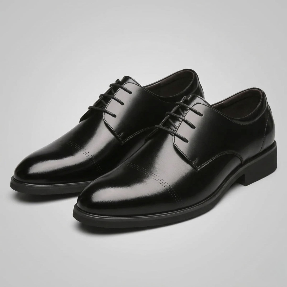 Pair of FORCIANO CAVELLO black elevator dress shoes with premium leather uppers shown from a front three-quarter studio angle.