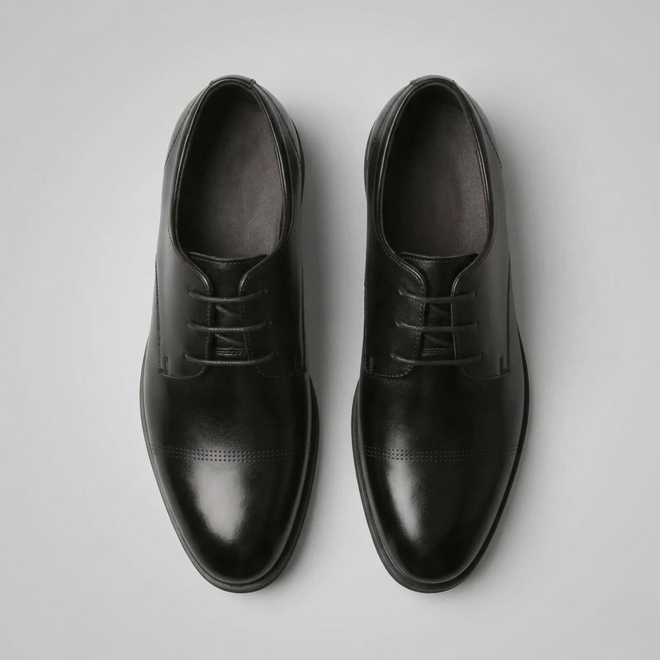 Top view of a pair of FORCIANO CAVELLO black elevator dress shoes with premium leather uppers and smooth cap-toe detailing.