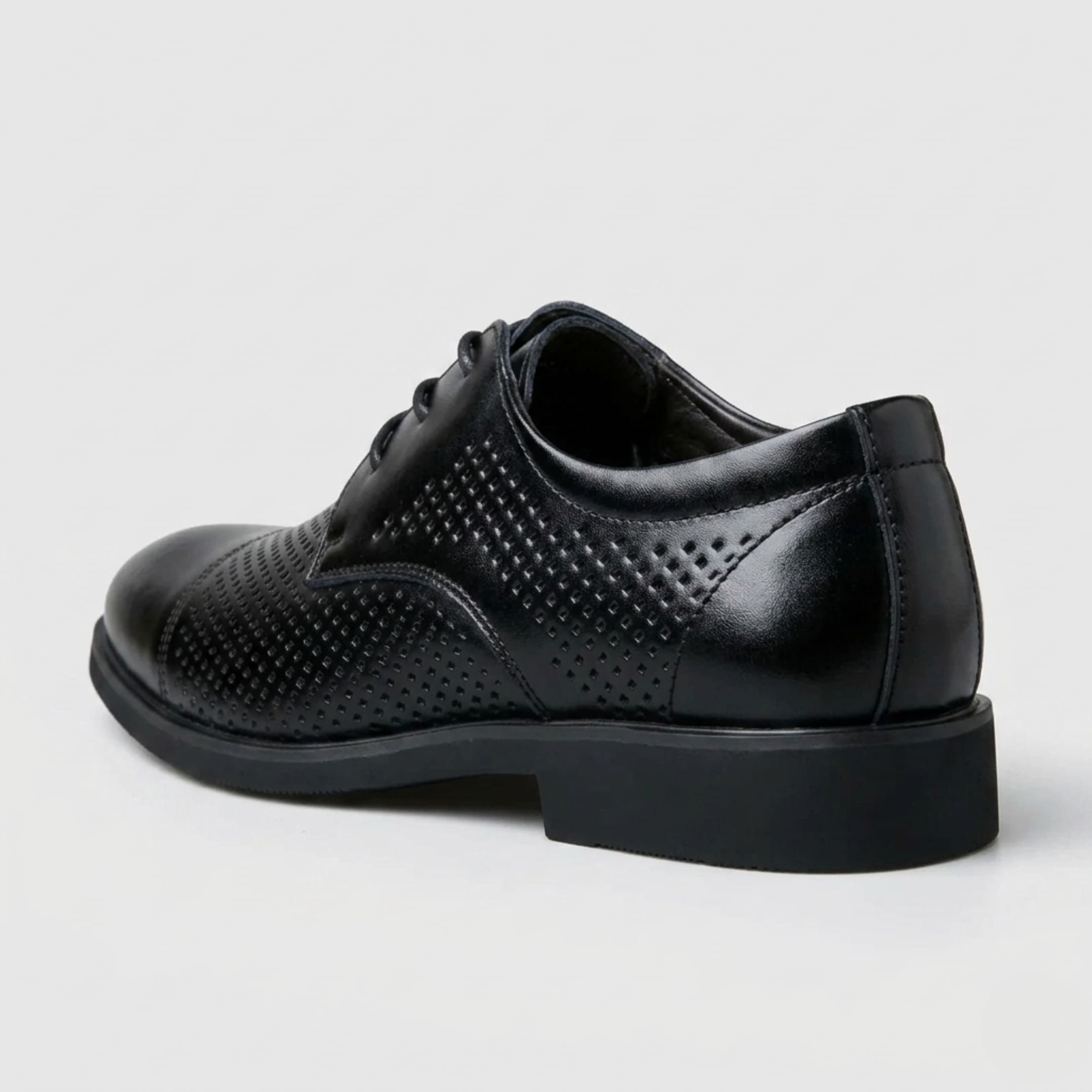 Rear three-quarter view of a FORCIANO CAVELLO black perforated elevator dress shoe with premium leather upper showing the perforated side and heel.
