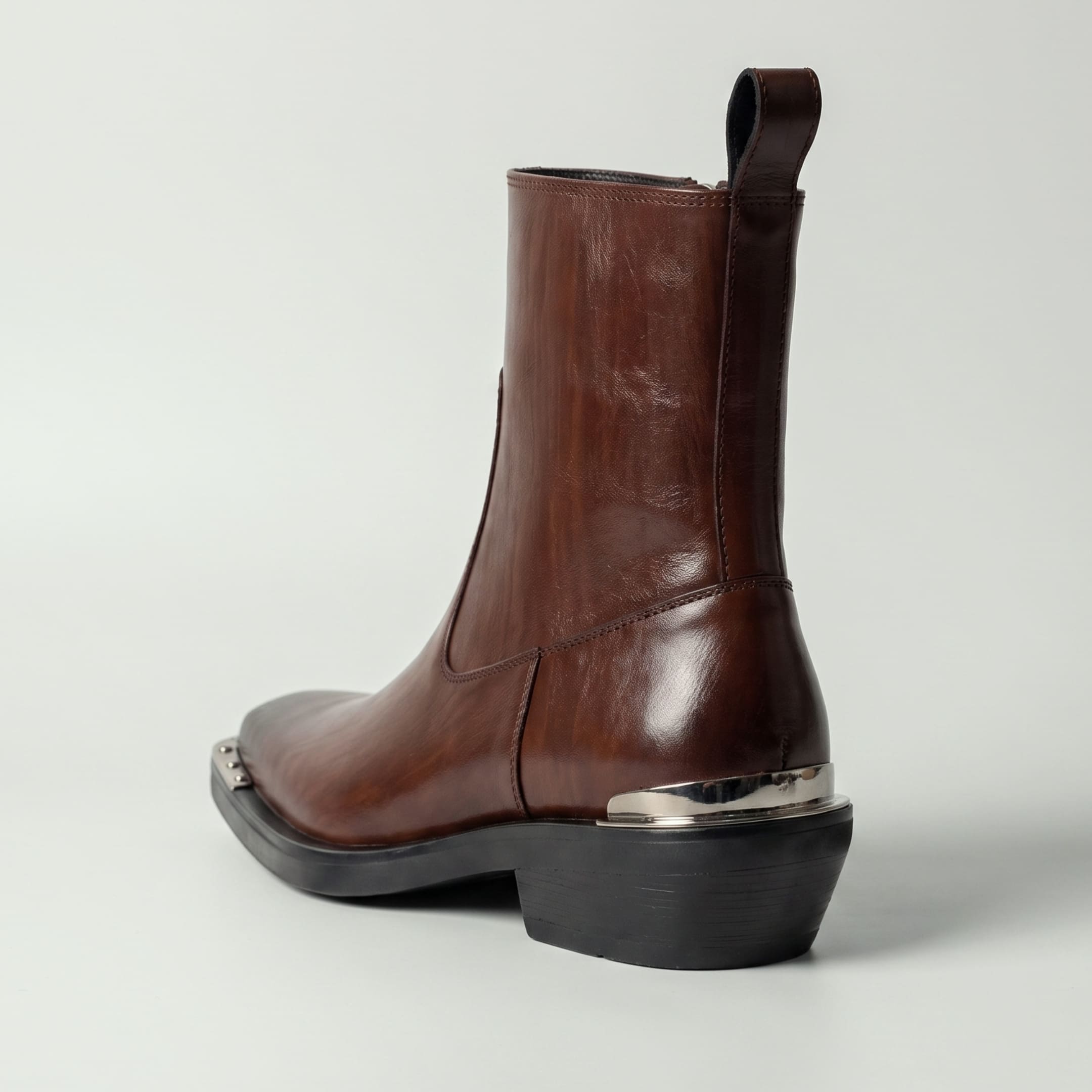 FORCIANO FERRANTE Elevator Boots in dark brown, shown from a rear three-quarter view with a smooth microfiber upper, pull tab, raised heel, and metallic heel detail.