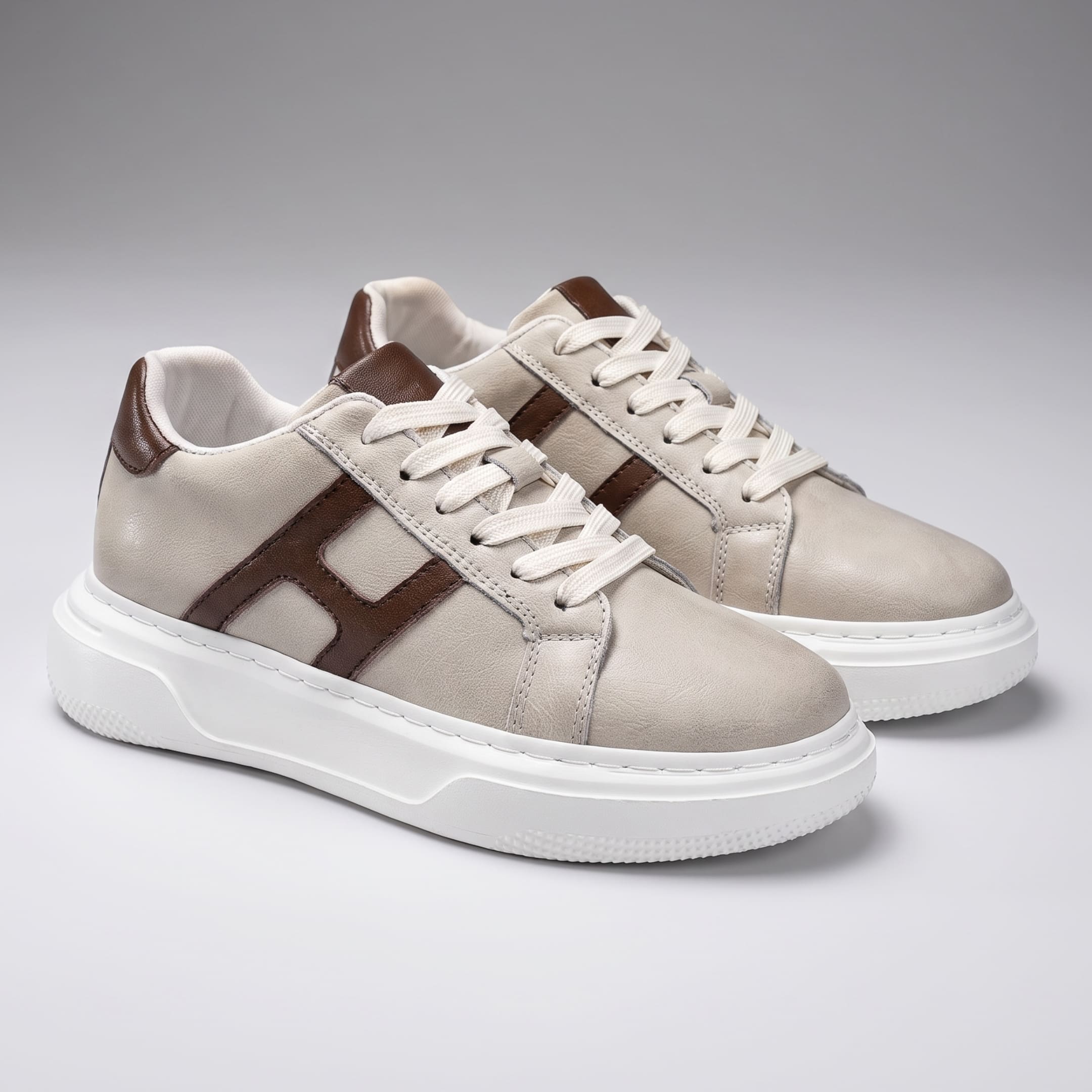 Pair of FORCIANO HERCULES beige premium leather Height Increasing Sneakers in front three-quarter view with brown accents and white soles.