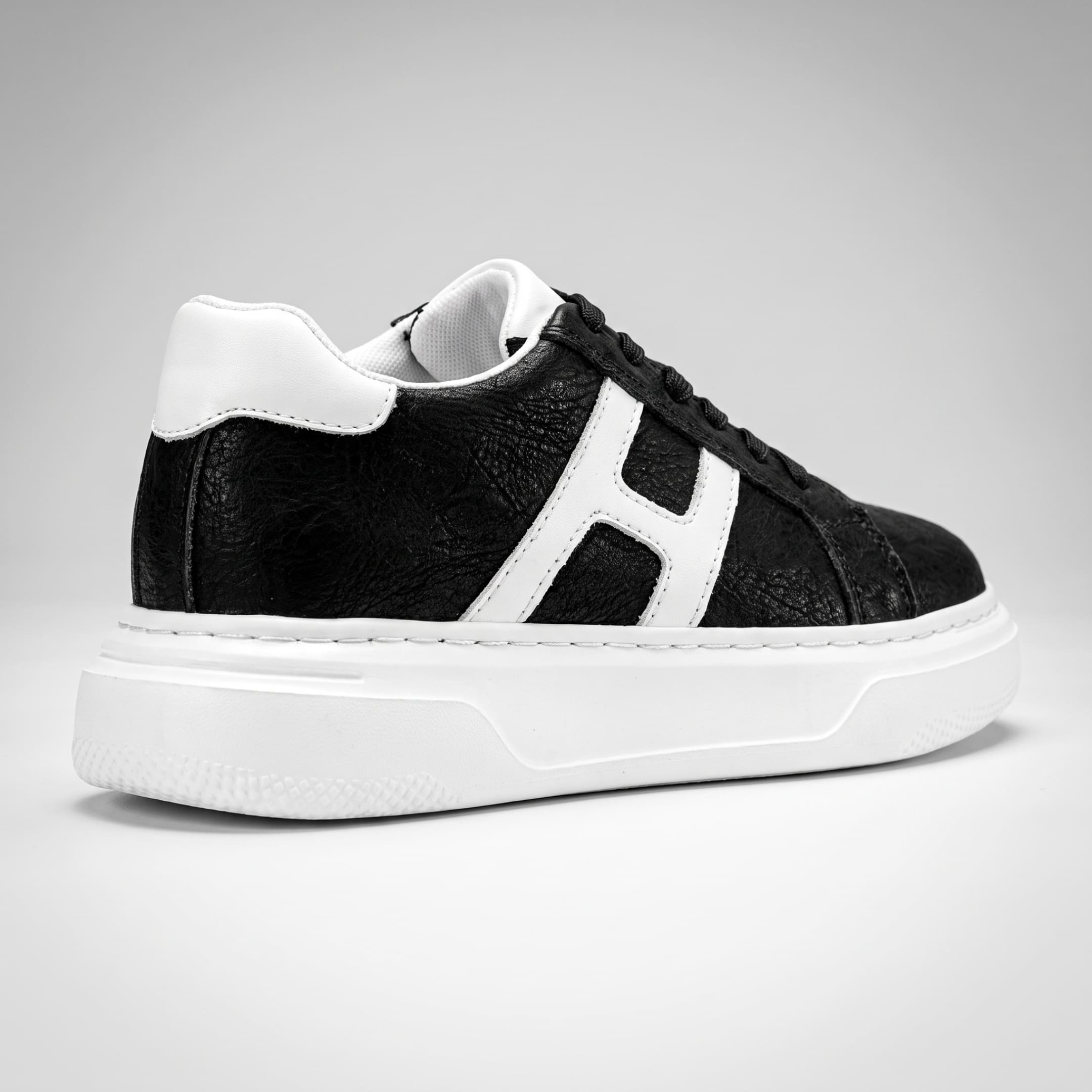 FORCIANO HERCULES black premium leather Height Increasing Sneaker shown from the rear three-quarter angle with white side accent and sole.