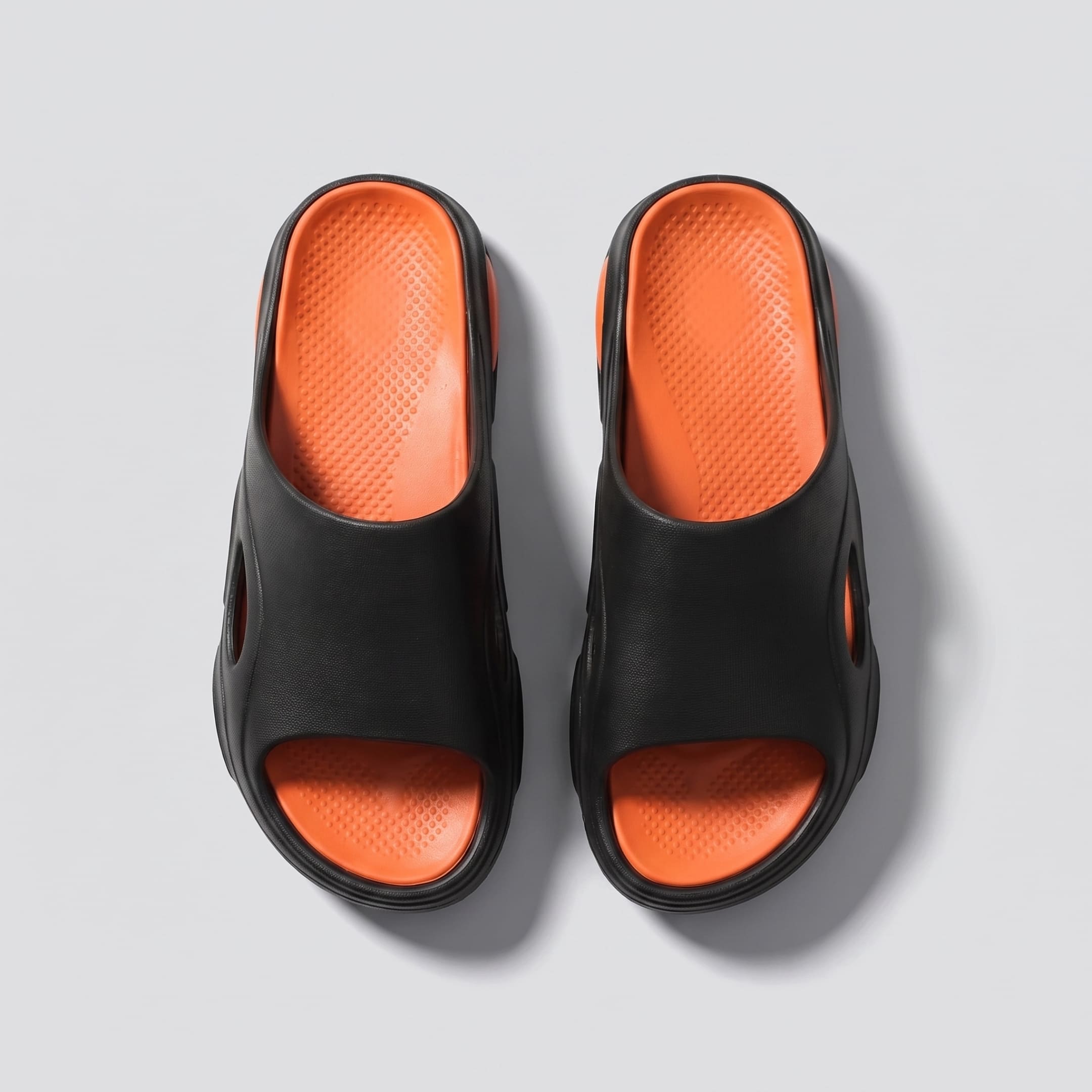 Top view of black-and-orange FORCIANO VECTOR EVA sandals shown as a pair of height increasing shoes with textured orange footbeds.