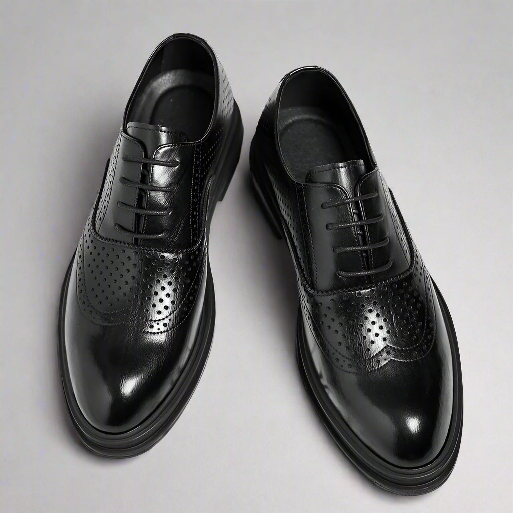 Black dress shoes with a thick platform on a white background