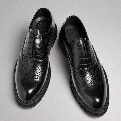 Black dress shoes with a thick platform on a white background