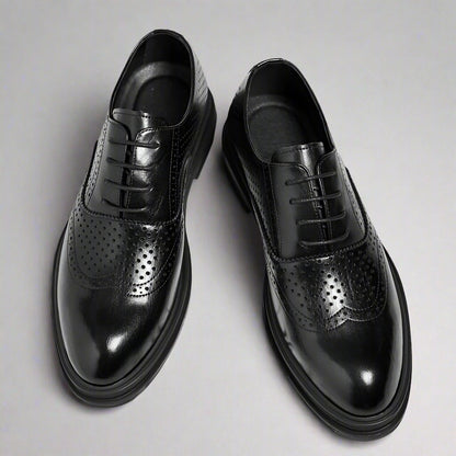 Black dress shoes with a thick platform on a white background