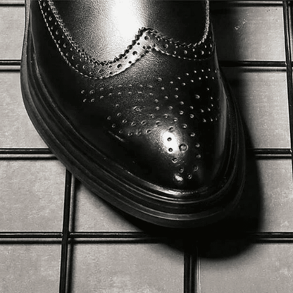 Close-up of the FORCIANO ALTIER black leather elevator boot toe showing polished finish, brogue perforations and layered sole edge.