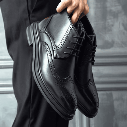 FORCIANO ALTIER black leather elevator boots held as a pair, showing the lace-up design, perforated detailing and raised boot profile.