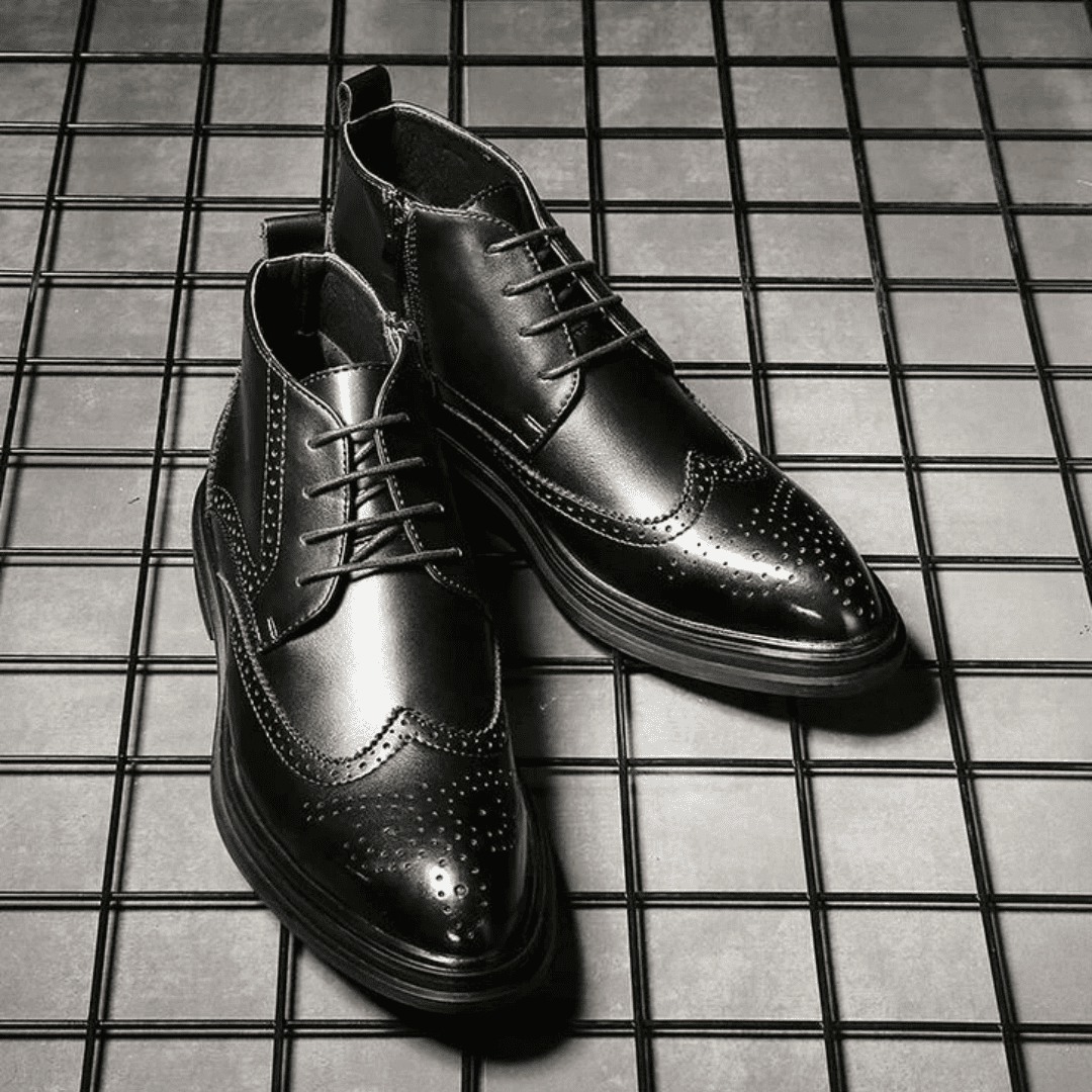 FORCIANO ALTIER black leather elevator boots arranged as a pair on a grid surface, showing front and angled views with brogue detailing.