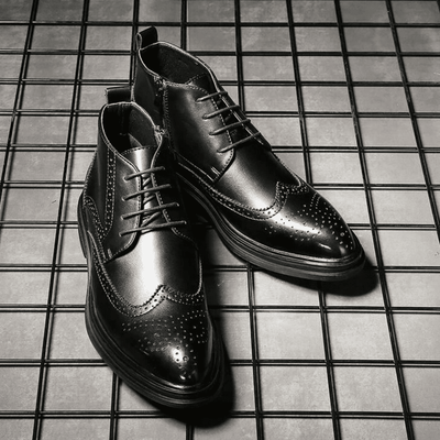 FORCIANO ALTIER black leather elevator boots arranged as a pair on a grid surface, showing front and angled views with brogue detailing.