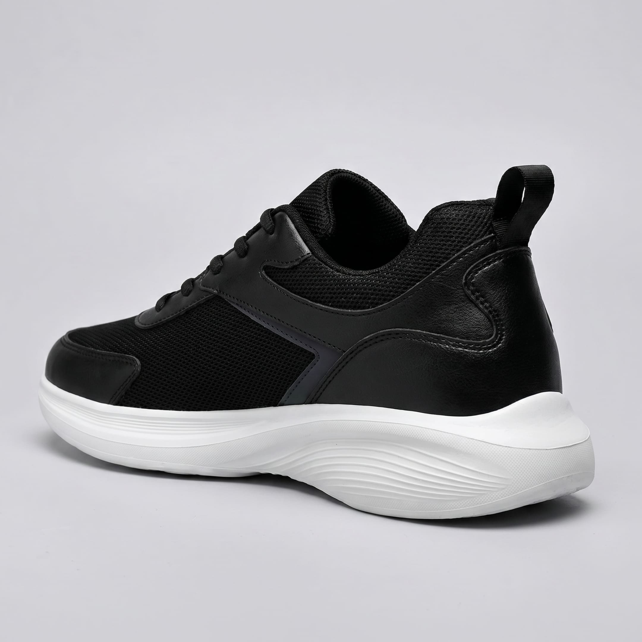 FORCIANO ASTOR black sneaker with a Flyknit mesh upper and white sole shown from a rear three-quarter side angle.