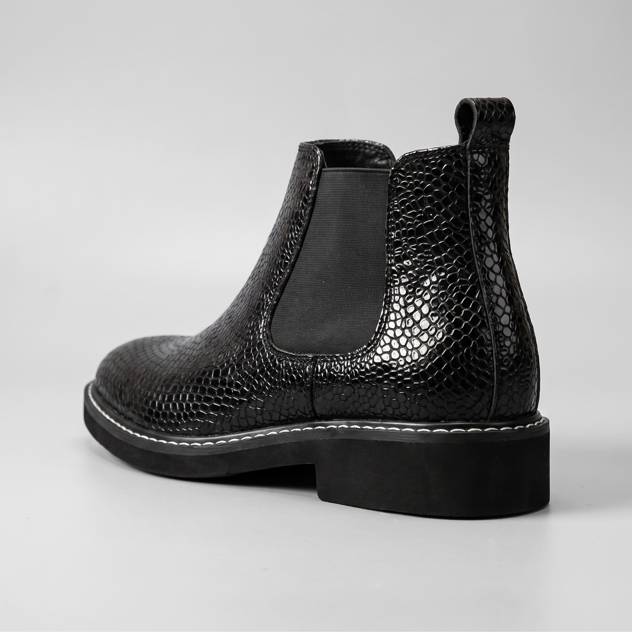 FORCIANO BRIXTON black women's elevator boot in rear three-quarter view, highlighting the textured premium leather upper, pull tab and elastic side panel.