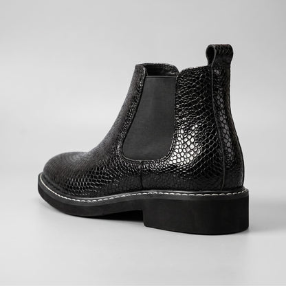FORCIANO BRIXTON black women's elevator boot in rear three-quarter view, highlighting the textured premium leather upper, pull tab and elastic side panel.