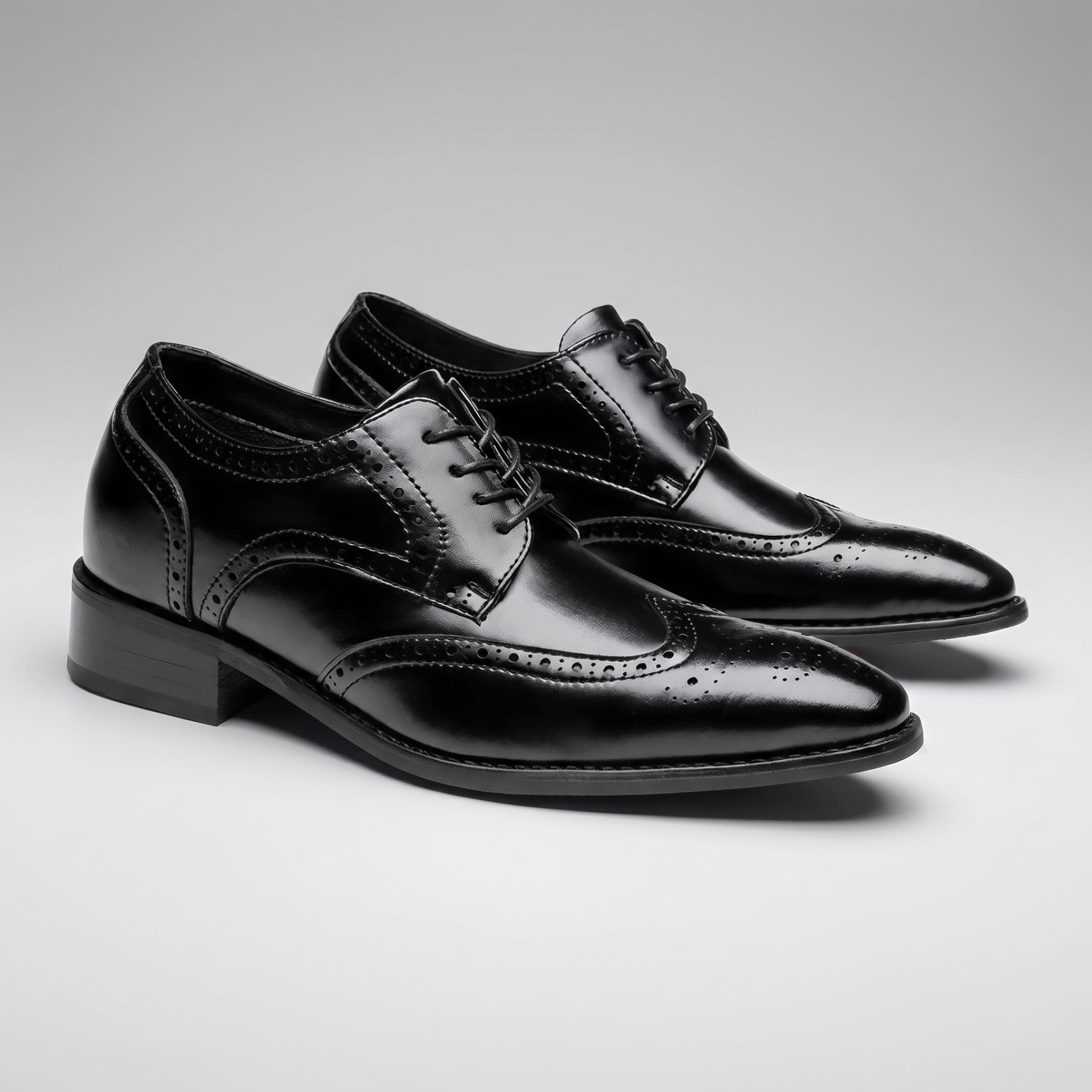 FORCIANO BROGUE black premium leather elevator dress shoes shown as a pair from a front three-quarter angle with polished brogue detailing.