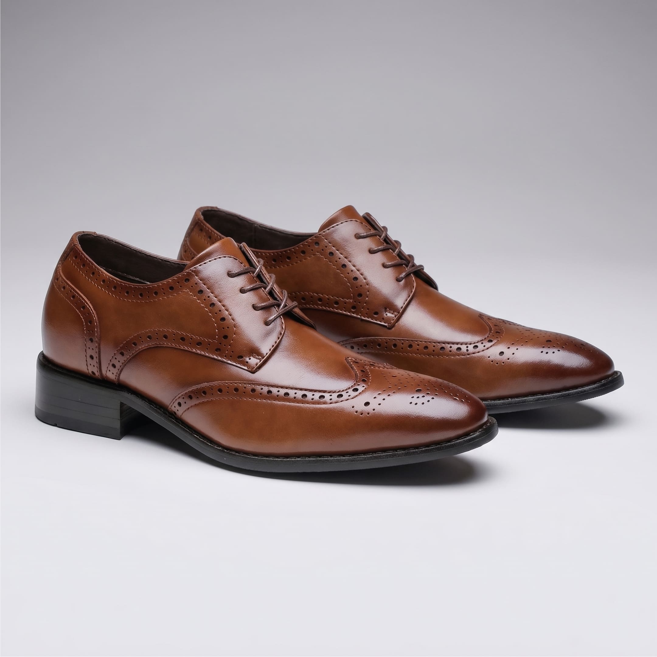 FORCIANO BROGUE brown premium leather elevator dress shoes shown as a pair from a front three-quarter angle with wingtip brogue detailing.