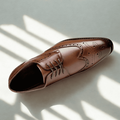 FORCIANO BROGUE brown premium leather elevator dress shoe shown from a top three-quarter angle with wingtip perforations and lace-up design.