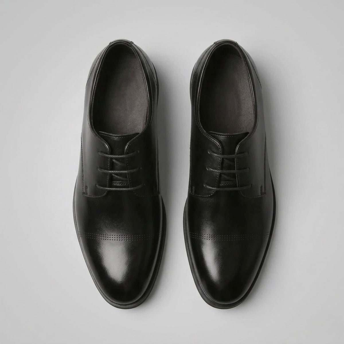 Top view of a pair of FORCIANO CAVELLO black elevator dress shoes with premium leather uppers and smooth cap-toe detailing.