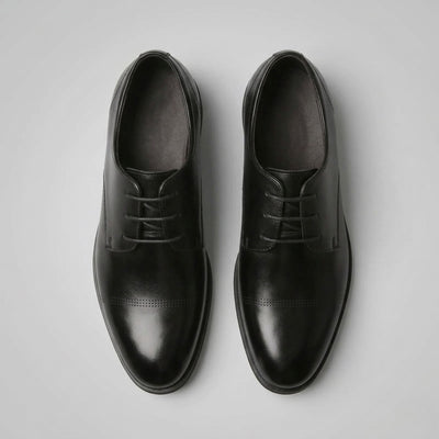 Top view of a pair of FORCIANO CAVELLO black elevator dress shoes with premium leather uppers and smooth cap-toe detailing.