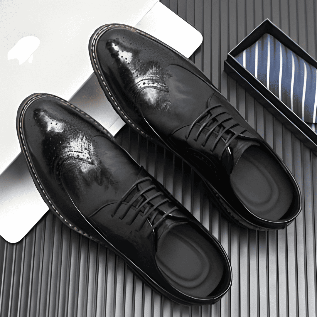 FORCIANO CELSUS black elevator dress shoes with premium leather uppers arranged from above beside a striped tie box.
