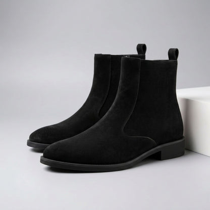 FORCIANO ECLIPSE black suede Chelsea boots arranged as a pair beside a white display block in a studio setting.
