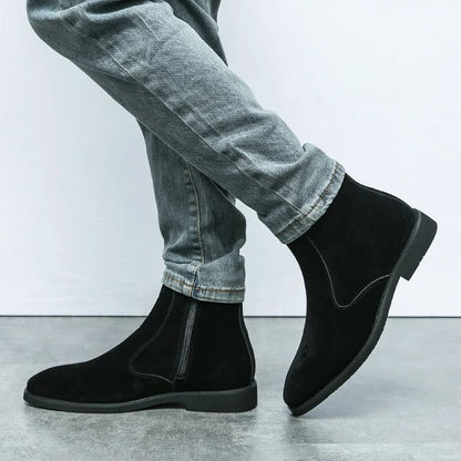FORCIANO ECLIPSE black suede Chelsea boots shown on foot with gray jeans in a crossed-leg lifestyle close-up.