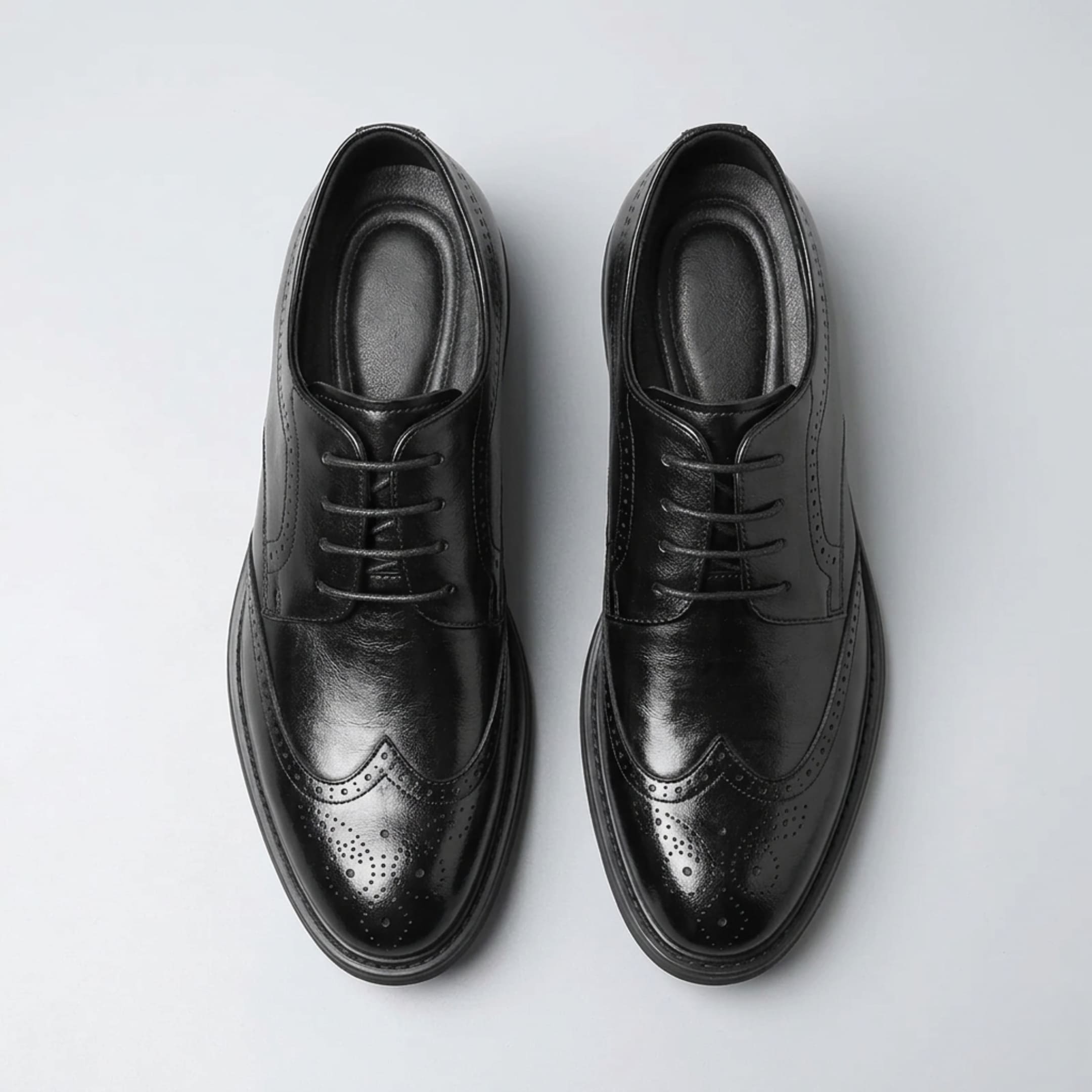 Top view of a pair of FORCIANO FAIRMONT black height increasing dress shoes showing laces, openings and brogue toe detailing.