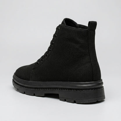 FORCIANO FORTITUDE black elevator boots shown from a rear three-quarter angle with lace-up construction and black lug sole.