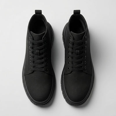 Pair of FORCIANO FORTITUDE black elevator boots shown from the top, highlighting the laces, openings and rounded toe design.