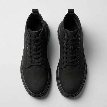 Pair of FORCIANO FORTITUDE black elevator boots shown from the top, highlighting the laces, openings and rounded toe design.