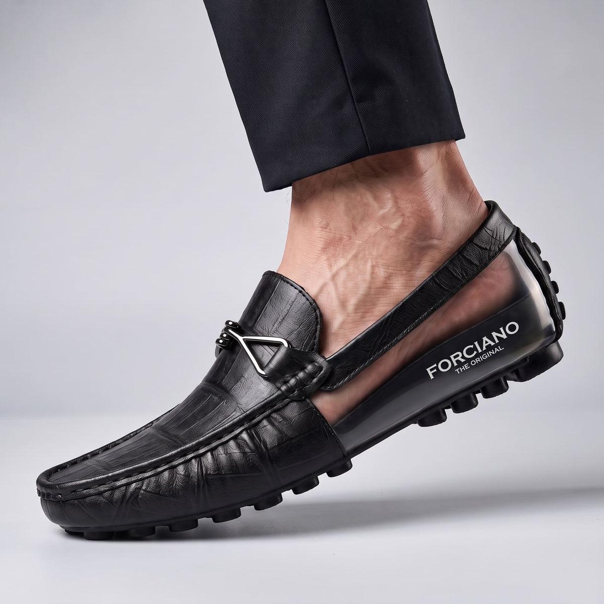 Close-up of a black leather FORCIANO HERITAGE Elevator Loafer worn on foot, revealing the branded internal lift and textured rubber sole.