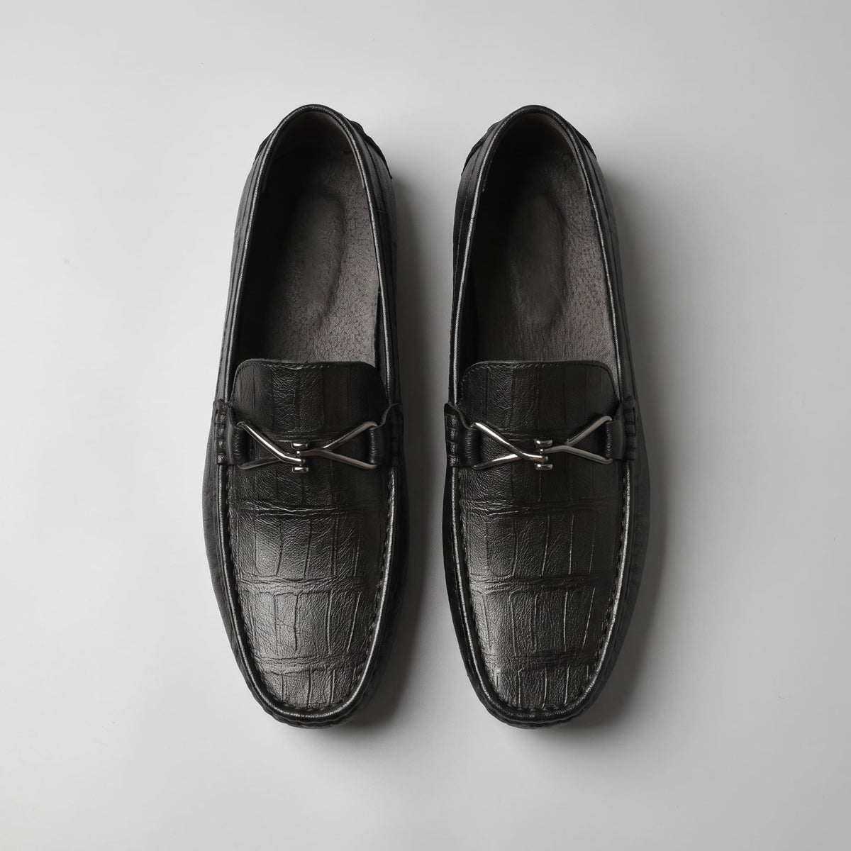 Top view of black leather FORCIANO HERITAGE Elevator Loafers arranged side by side, displaying their square toes, metal accents and interior lining.