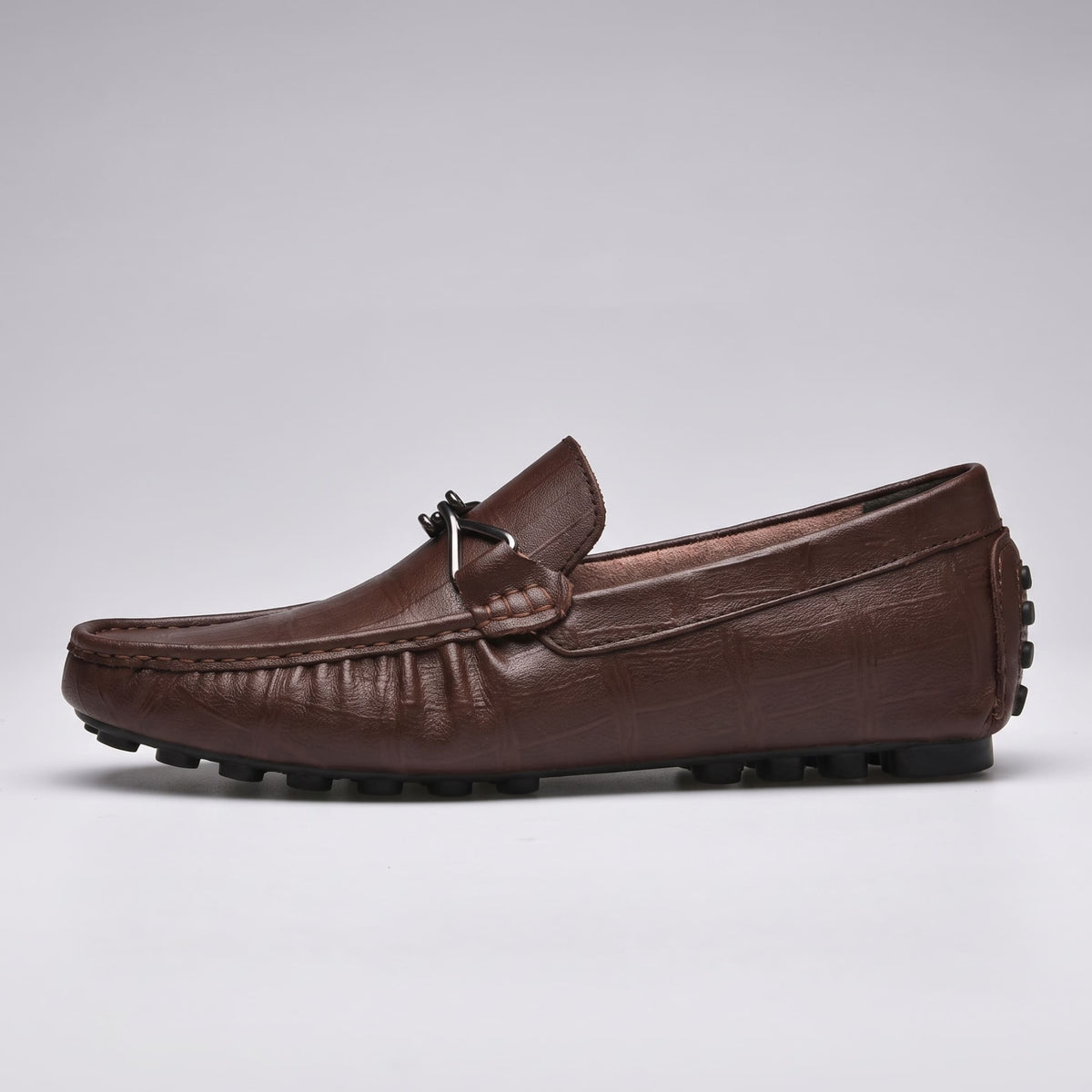 FORCIANO HERITAGE Elevator Loafers in brown leather, single shoe side profile showing the metal accent, stitched moccasin toe and black rubber studs.