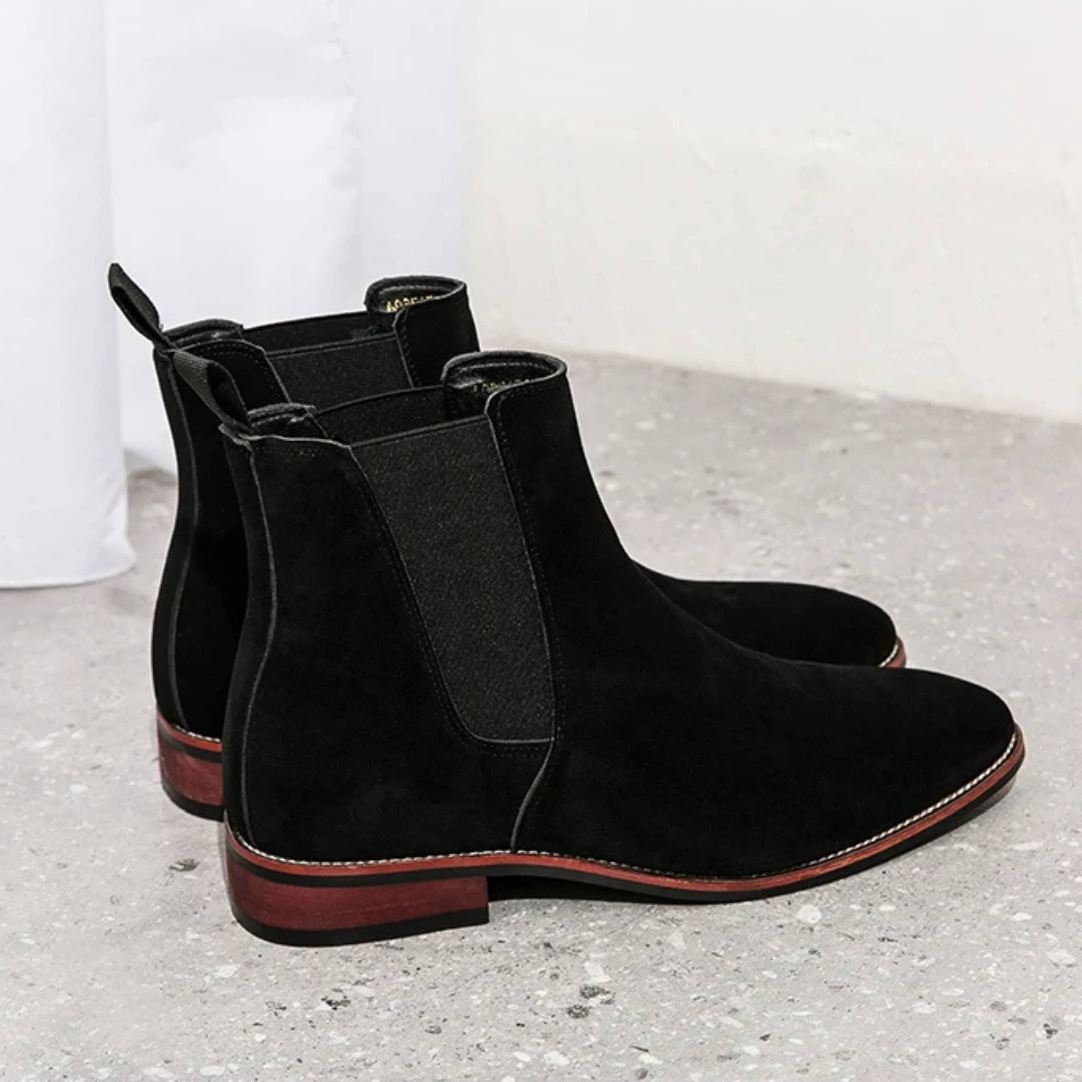 FORCIANO IVORY black suede elevator boots shown as a pair from a rear-side angle with elastic panels.