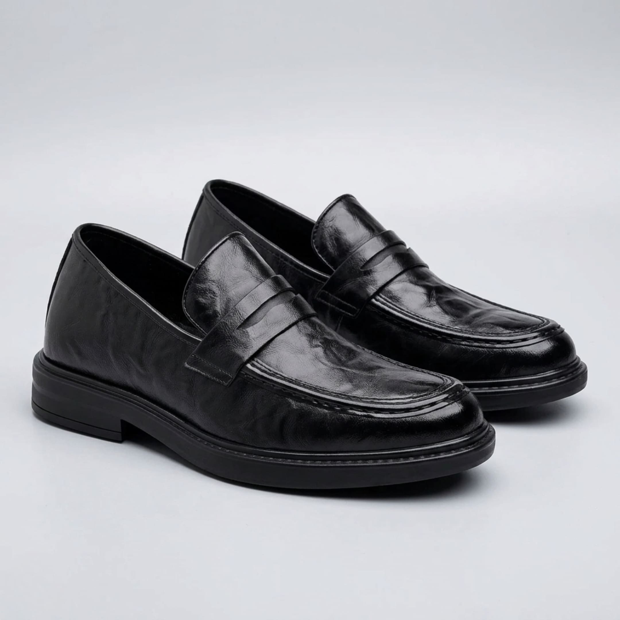 FORCIANO KINGSLEY black leather height increasing loafers shown as a pair from a front three-quarter angle with classic penny straps.