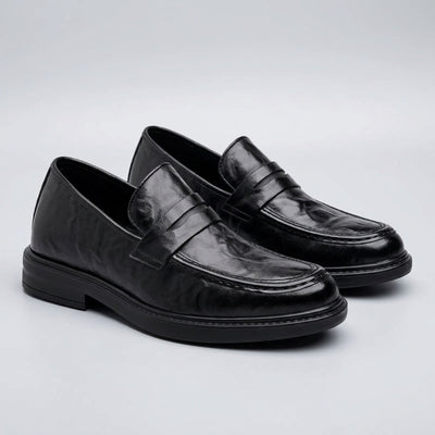 FORCIANO KINGSLEY black leather height increasing loafers shown as a pair from a front three-quarter angle with classic penny straps.
