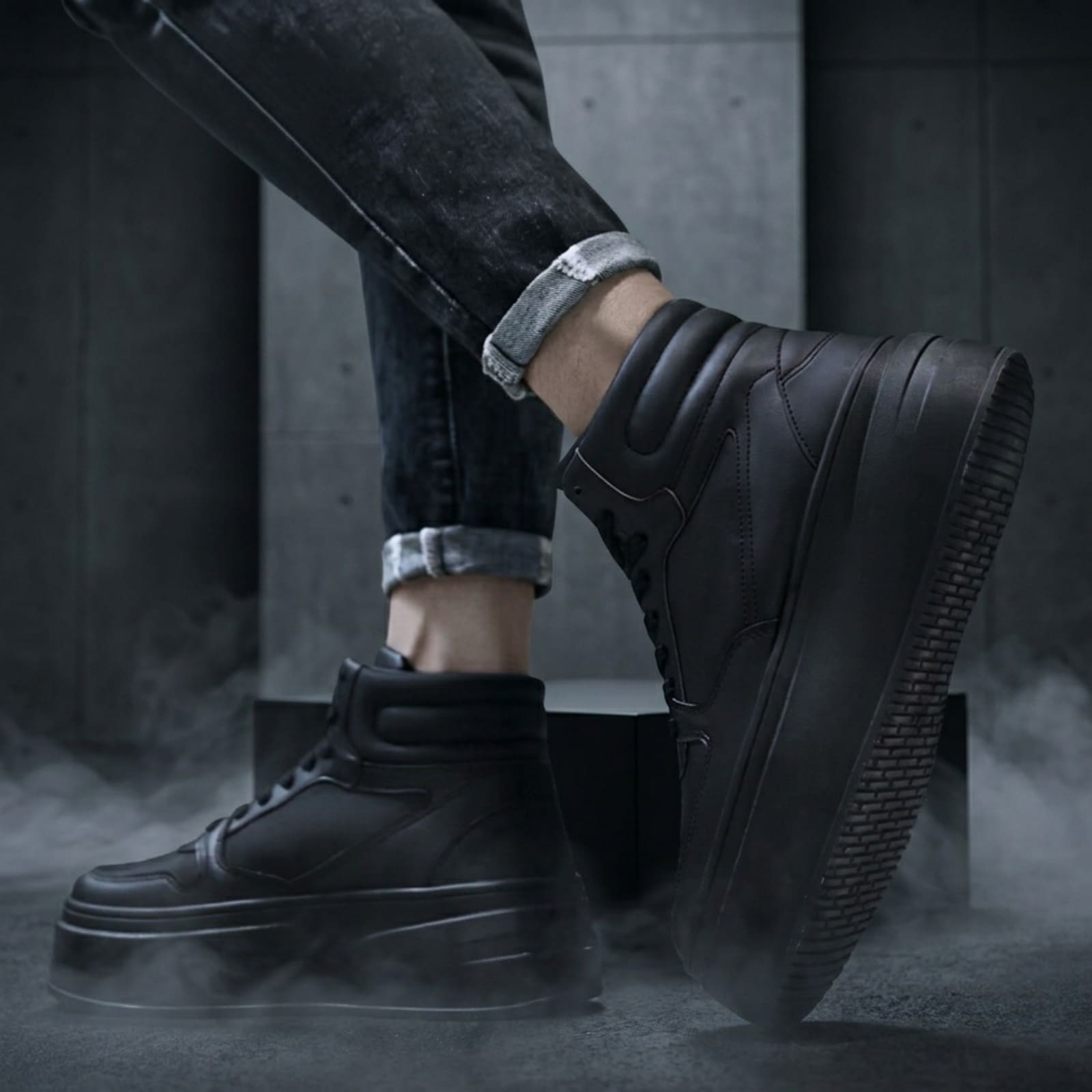 FORCIANO MONARCH black height increasing sneakers worn in a lifestyle view with one shoe raised to show the side profile and outsole.