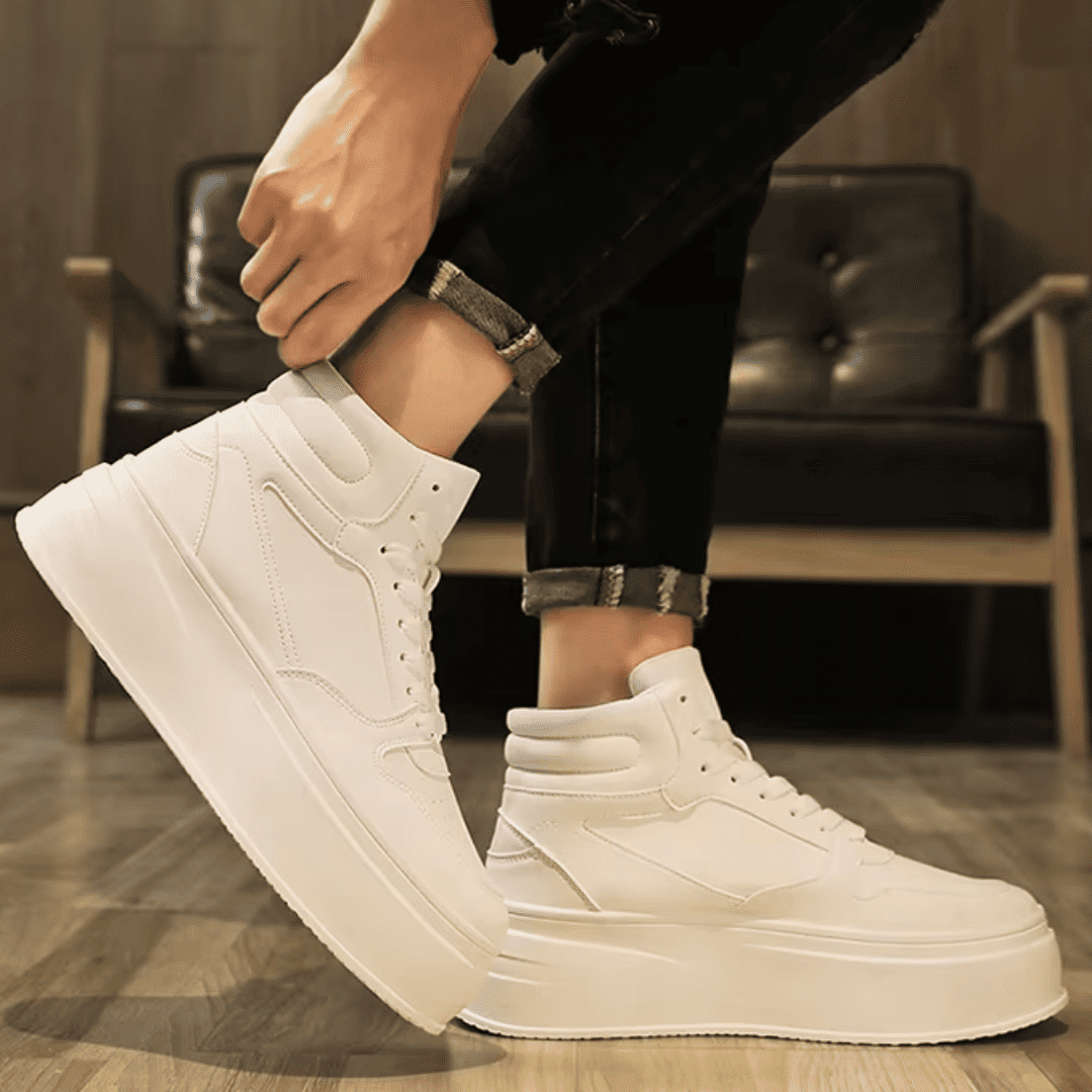 FORCIANO MONARCH white height increasing sneakers worn in a side-angle lifestyle view with one shoe raised and the high-top profile visible.