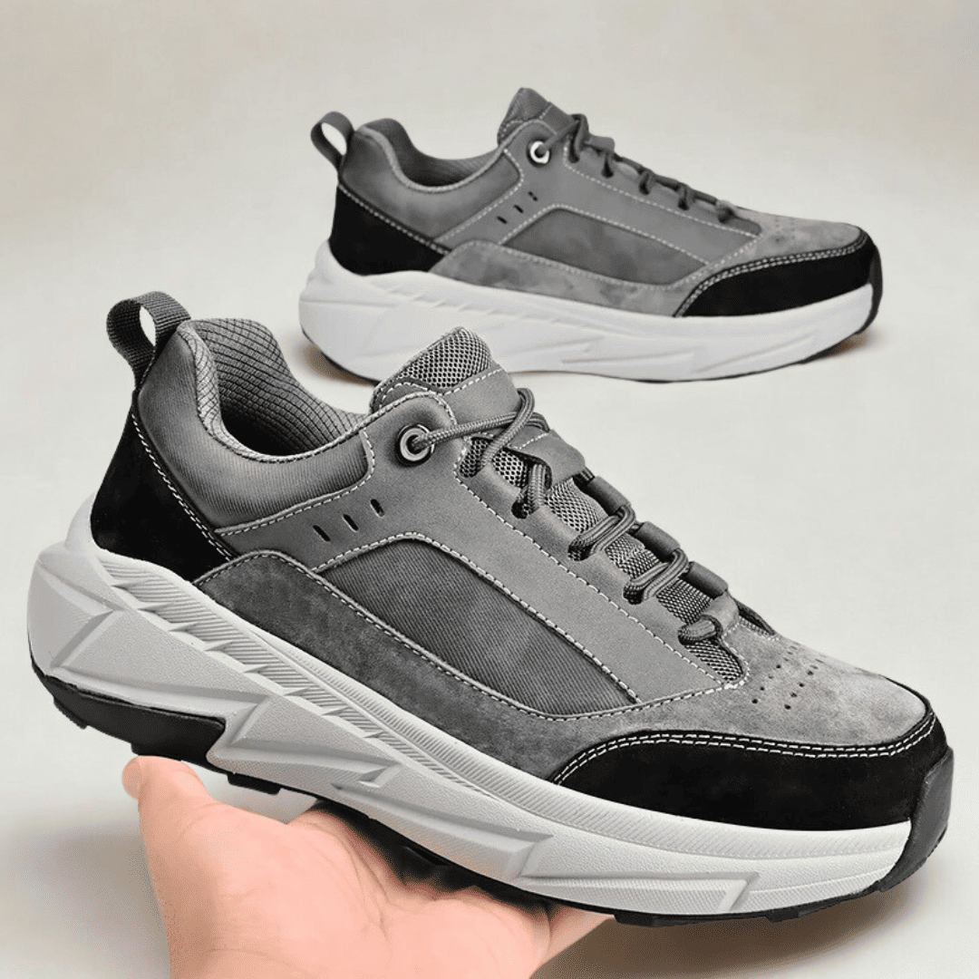 FORCIANO NORTHRIDGE gray and black height increasing sneakers shown as a pair, with the foreground sneaker held in hand at an angled side view.