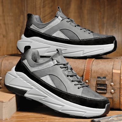 FORCIANO NORTHRIDGE gray and black height increasing sneakers displayed as a pair from angled side views beside wooden cases.