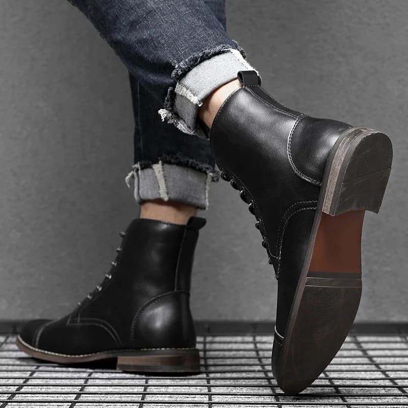 FORCIANO OUTLAW black leather height increasing boots worn with rolled jeans, showing the outsole, heel and rear profile.