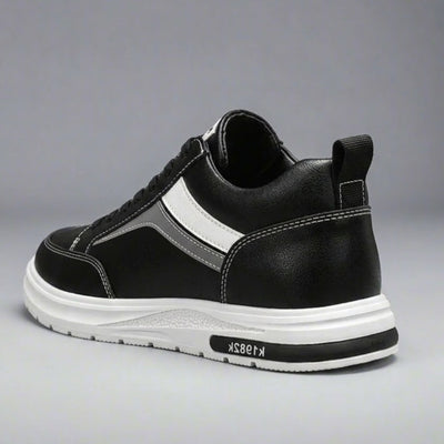 FORCIANO PRIME black height increasing sneakers with white and gray reflective accents shown from a rear three-quarter angle, featuring contrast stitching and a white sole.