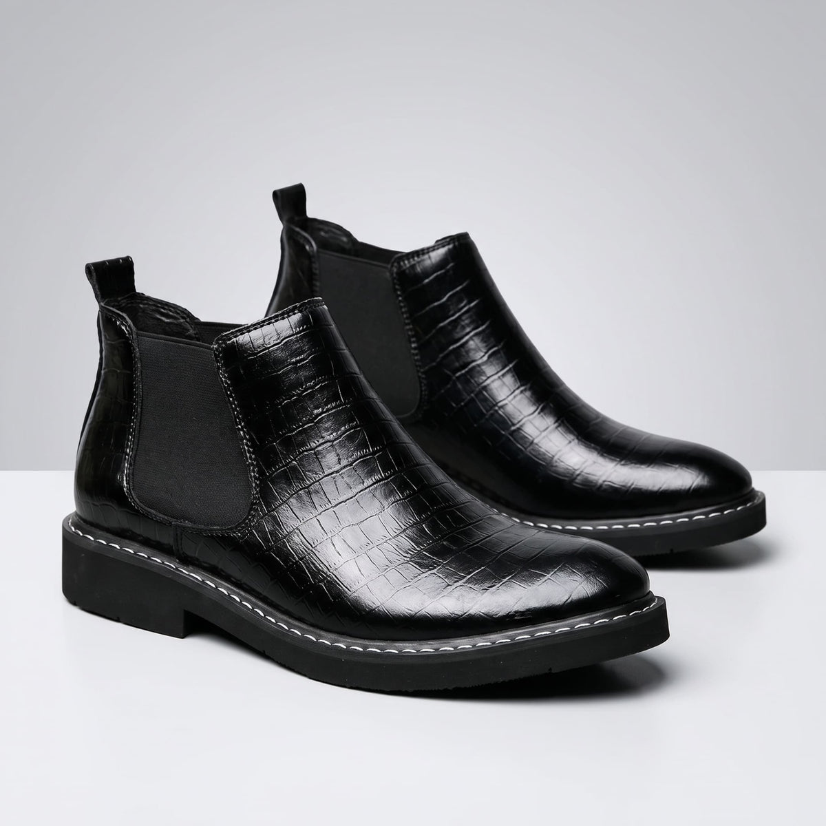 FORCIANO RAPTOR men's elevator boots in black shown as a pair from a front three-quarter angle with textured uppers and elastic side panels.