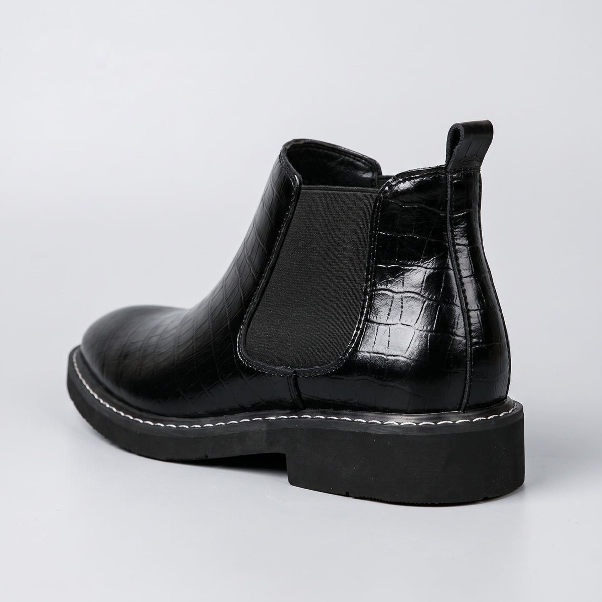 FORCIANO RAPTOR men's elevator boots in black shown from the rear three-quarter angle with elastic side panel, pull tab and raised heel profile.