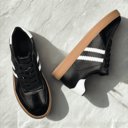 FORCIANO SABER black height increasing sneakers with white stripes, gum soles and split leather uppers arranged as a pair in an overhead view.